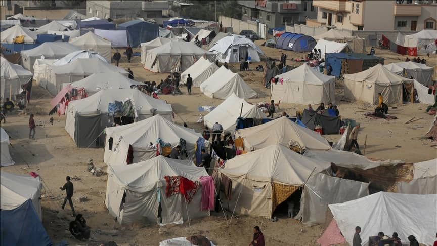 Rows of white tents crowd a vast refugee camp