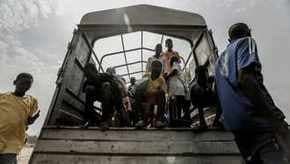 People crowding onto the back of a truck