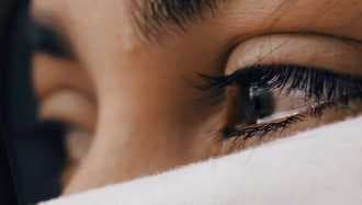 Close-up of a person's eye above a white cloth