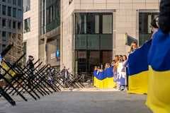 Люди с украинскими флагами за уличными ограждениями